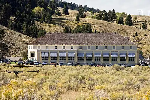 Interior of the Mammoth Hot Springs Hotel Dining Room with arched windows and set tables.