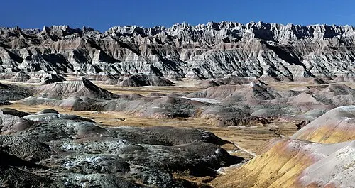 The Badlands Wall dropping from prairie tableland to eroded buttes, seen from Big Badlands Overlook.