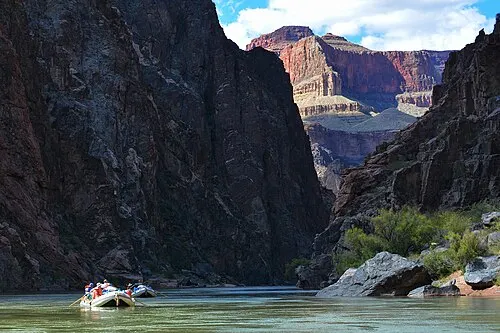 A raft on the Colorado River deep below the canyon rims in Grand Canyon National Park.