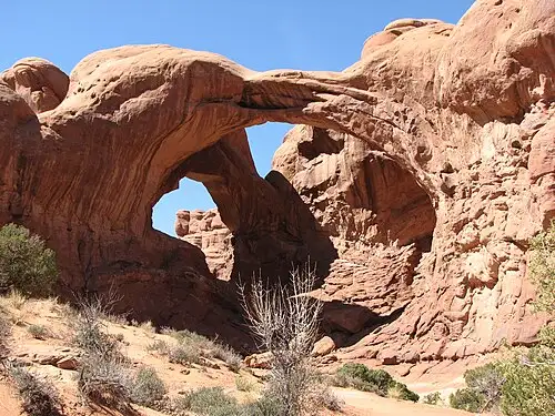 Double Arch in the Windows section, two large sandstone arches sharing one end of their span against a blue sky.