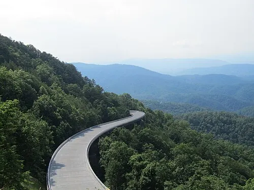 A viaduct bridge along the Foothills Parkway curves above forested slopes inside the park.