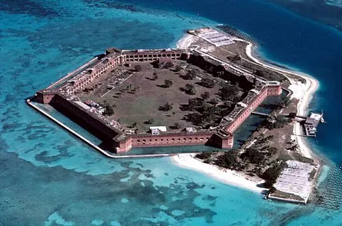 Aerial view of the six-sided masonry Fort Jefferson filling Garden Key, ringed by a moat wall and turquoise reef flats in the Dry Tortugas.