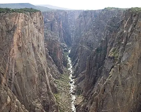 The Gunnison River seen from the inner gorge, narrow and shadowed between vertical metamorphic walls.