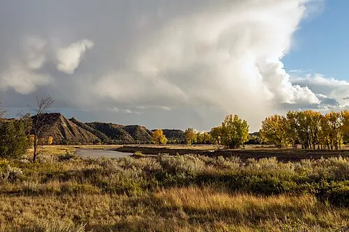 The Little Missouri River curving through cottonwood river bottom below badlands walls in Theodore Roosevelt National Park.