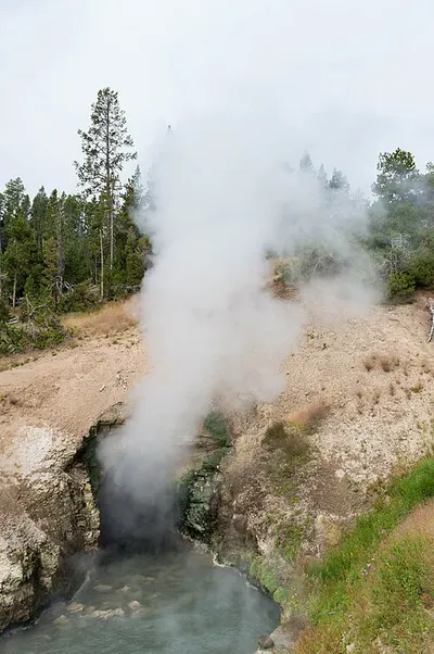 Dragon's Mouth Spring, a steaming cave-mouth hot spring at the edge of the Mud Volcano boardwalk.
