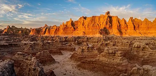 Late golden light across eroded Badlands spires and canyon near the Pinnacles area.