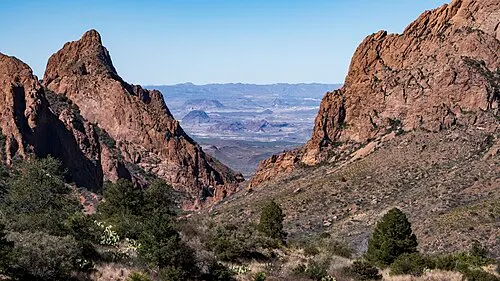 The V-shaped Window drainage gap in the Chisos Basin framing the desert beyond at sunset, Big Bend National Park.