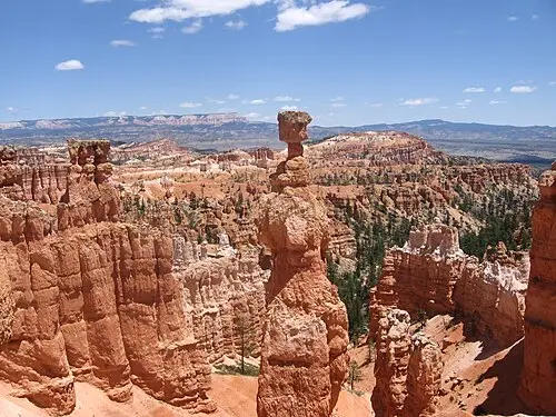 Thor's Hammer, a hoodoo with a wide capstone balanced on a slender pink column, standing above the Navajo Loop at Bryce Canyon.