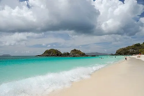 Crescent white-sand beach at Trunk Bay, St. John, with turquoise water and a forested headland.