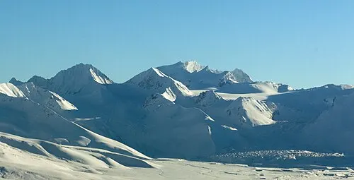 The ash-filled Valley of Ten Thousand Smokes stretching toward the snow-streaked Mount Katmai caldera rim.