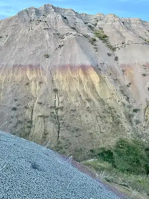 Banded yellow and red paleosol mounds below gray rock at Yellow Mounds Overlook, Badlands National Park.