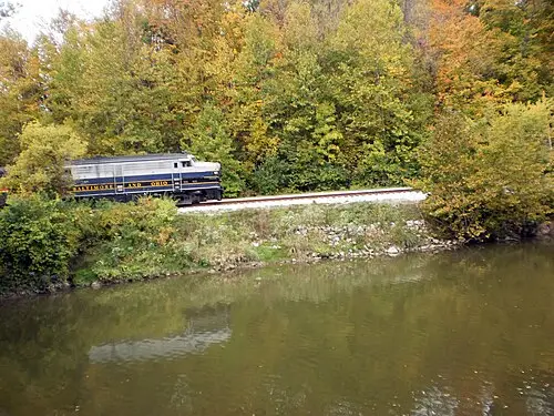A Cuyahoga Valley Scenic Railroad diesel locomotive crossing a bridge over the Cuyahoga River.