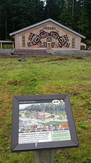 Exterior of Xunaa Shuka Hit, the Huna Tlingit tribal house at Bartlett Cove, with a carved and painted clan front.