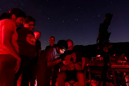 Visitors gathered at a Joshua Tree Night Sky Festival event under a clear desert sky.