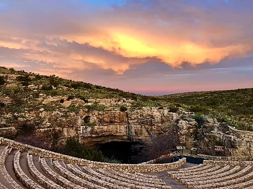 The concrete Bat Flight Amphitheater at the Natural Entrance at dusk, where rangers narrate the Brazilian free-tailed bat emergence.