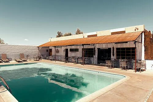 Adobe bungalow and palm-shaded grounds of the 29 Palms Inn at the Oasis of Mara in Twentynine Palms.