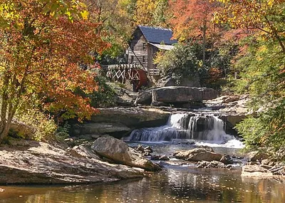 The Glade Creek Grist Mill below an autumn cascade in adjacent Babcock State Park (the mill stands in for the cabins).