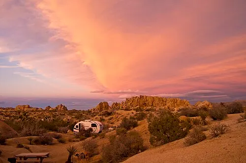 Camper trailer parked among monzogranite formations at Jumbo Rocks Campground in Joshua Tree.