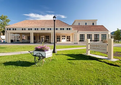 Exterior of the Mammoth Hot Springs Hotel with the Mammoth parade-ground lawn in the foreground.