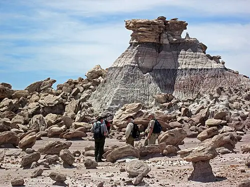 Hikers crossing open badland terrain in the backcountry wilderness of Petrified Forest National Park.