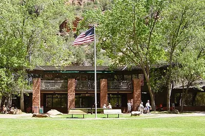 Zion Lodge and its lawn on the floor of Zion Canyon, the only lodging inside the canyon, beneath the sandstone walls.