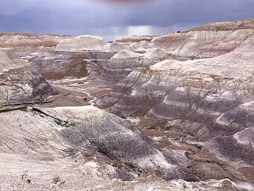 Paved Blue Mesa trail descending between blue and gray Chinle Formation badland hills, Petrified Forest National Park.