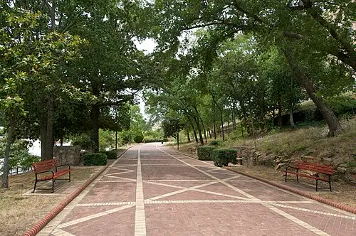 The Grand Promenade brick path with benches running behind the Bathhouse Row buildings.
