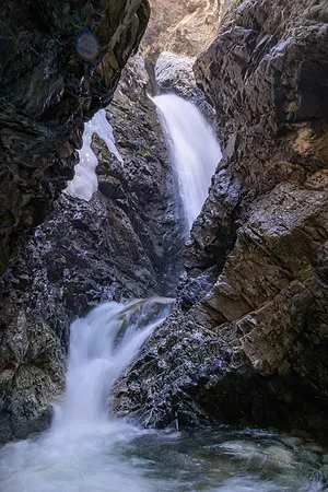 Zapata Falls cascading inside a narrow rock chasm in the Sangre de Cristo foothills south of the park.