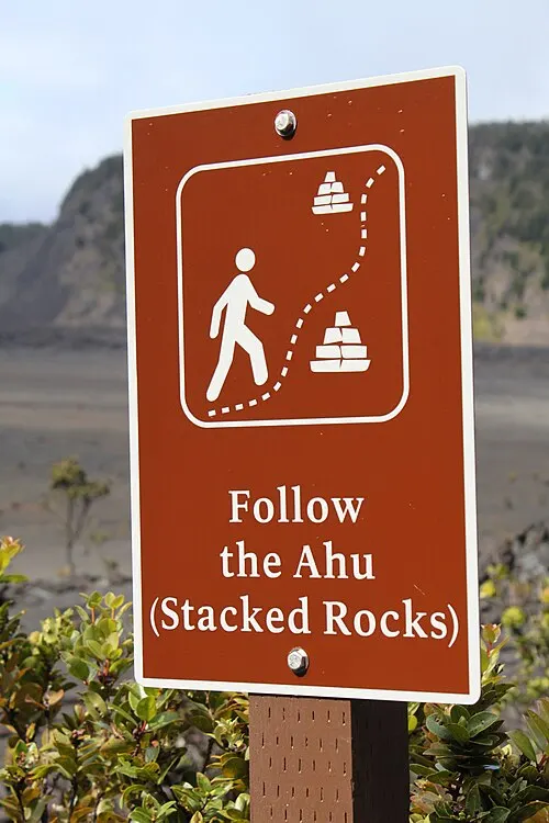 Walkers on a cinder-and-lava path through the recovering Kīlauea Iki area near Devastation Trail.