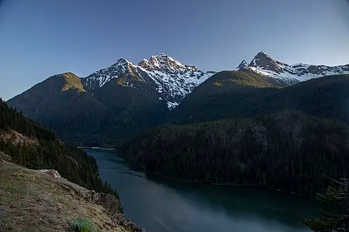 The signed Diablo Lake Overlook pullout on State Route 20 looking down on the turquoise reservoir and peaks.