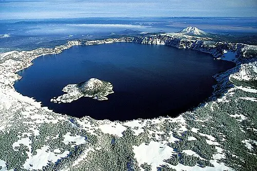 Level rim-edge view of Crater Lake and Wizard Island from a west-rim overlook near Rim Village.