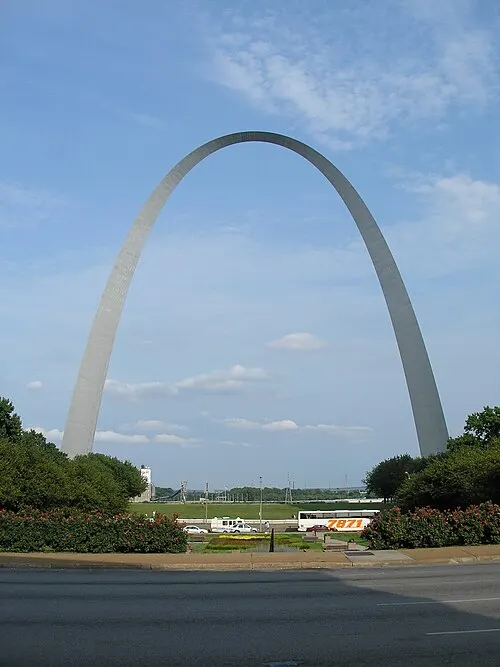 The Gateway Arch, a 630-foot stainless-steel catenary curve, rising over downtown St. Louis under a clear sky.